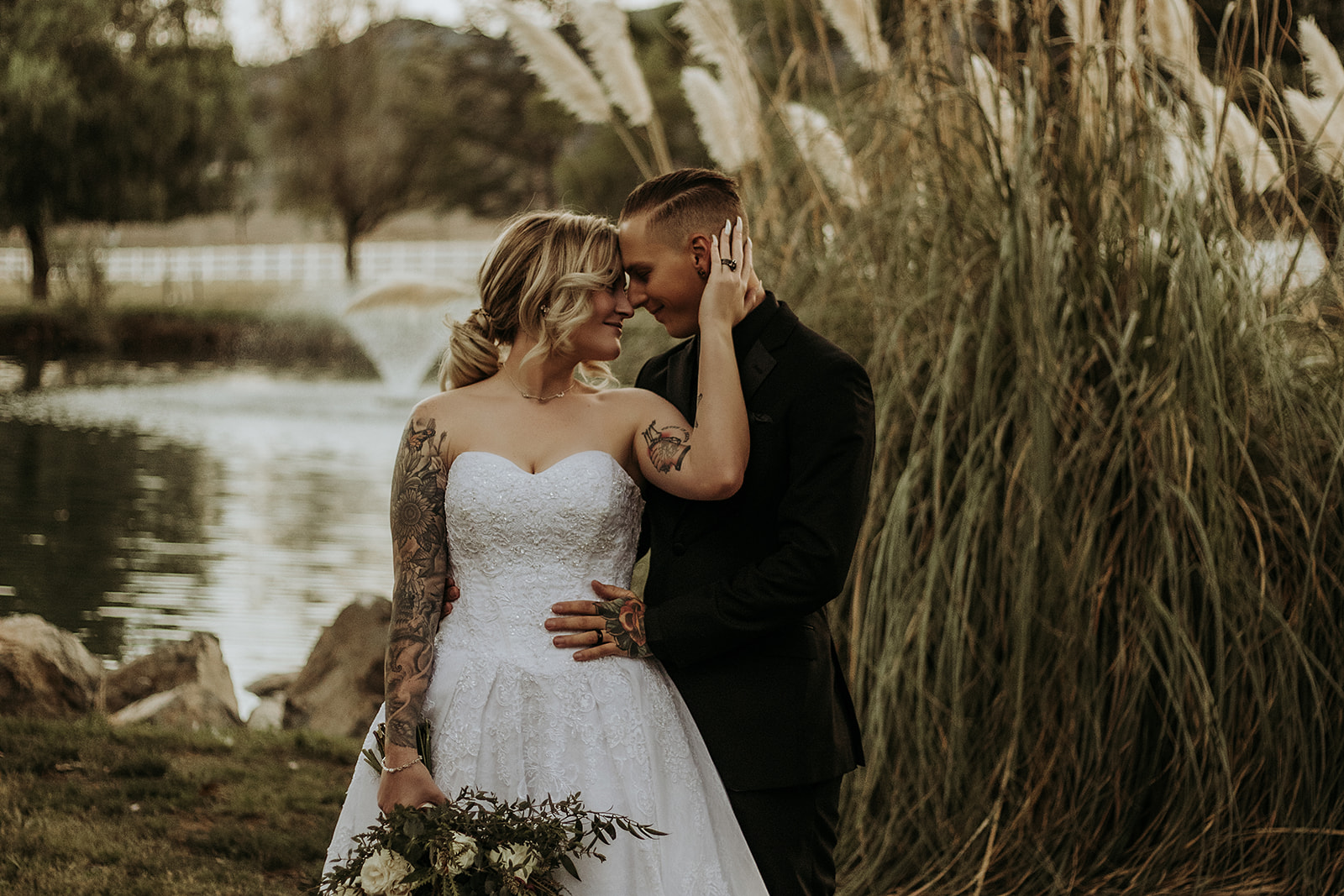 bride and groom embracing each other, brides hand on grooms head, foreheads touching